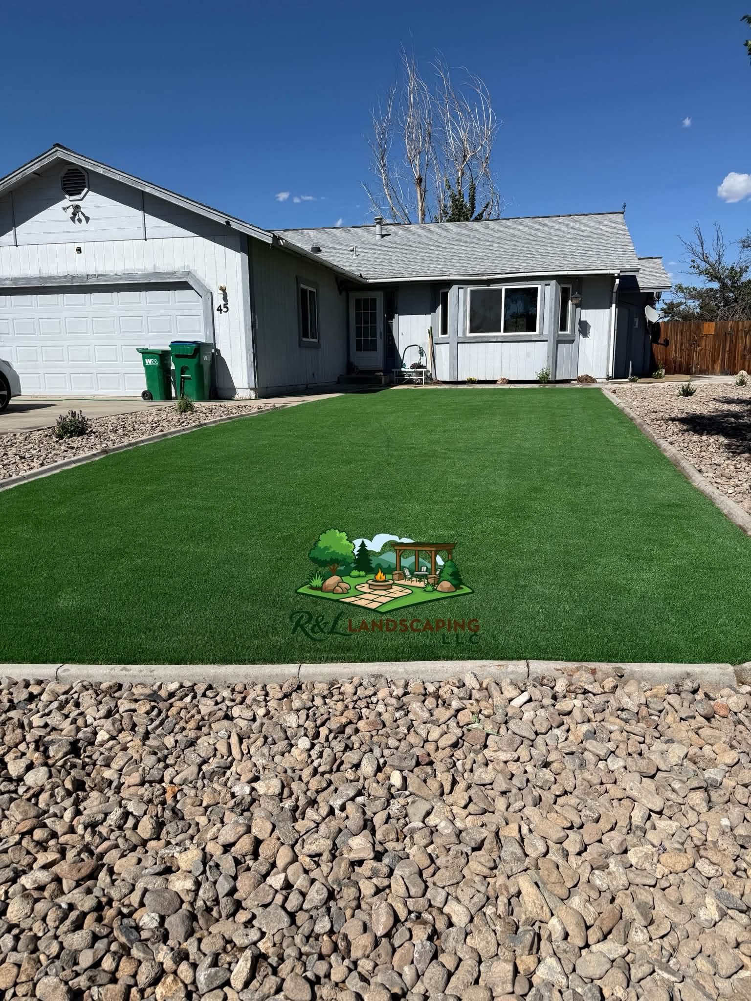 Same front yard after turf installation and rock border by R&L Landscaping LLC