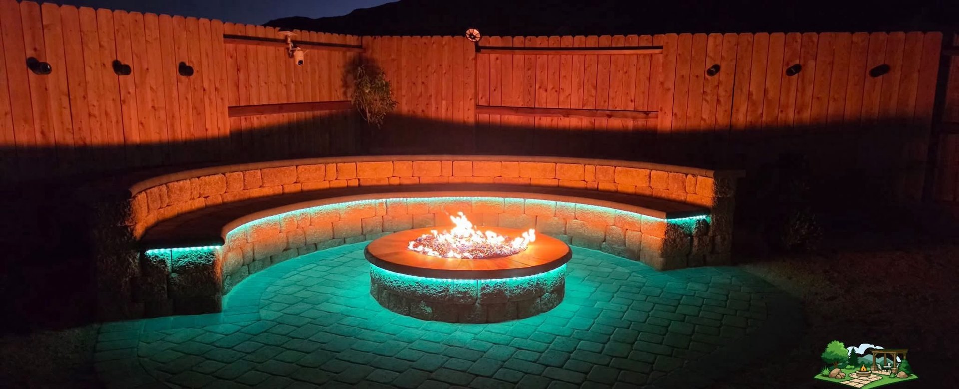 Completed paver patio with curved stone seat wall and fire pit built by R&L Landscaping LLC