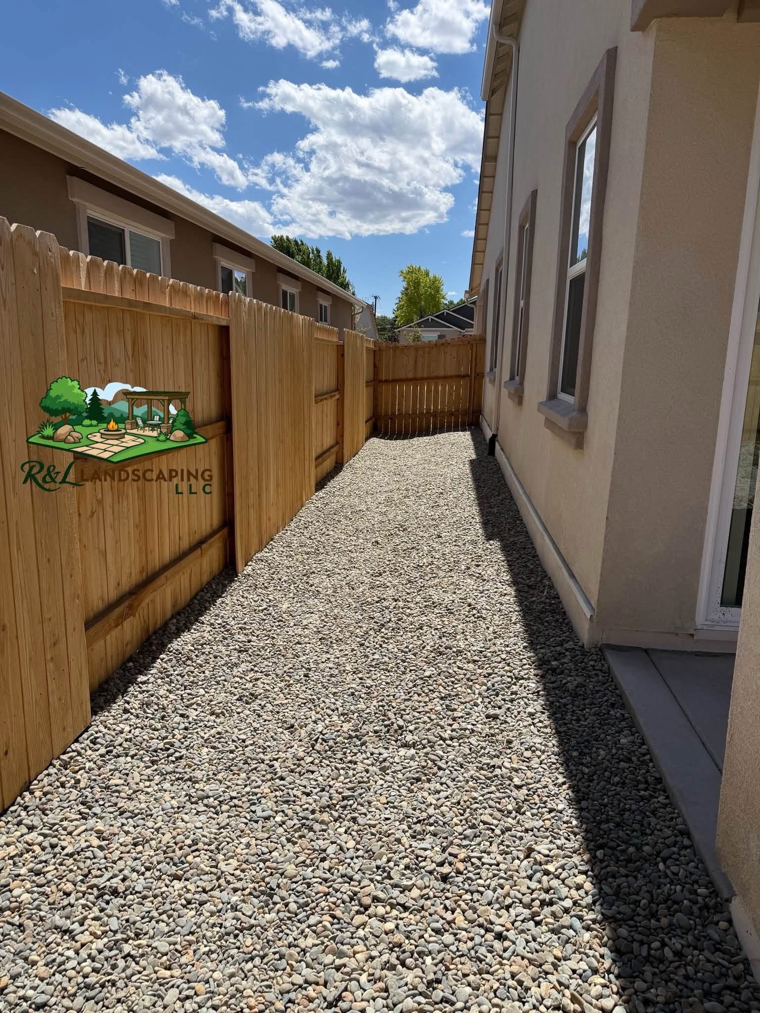 Same side yard after decorative rock installation by R&L Landscaping LLC