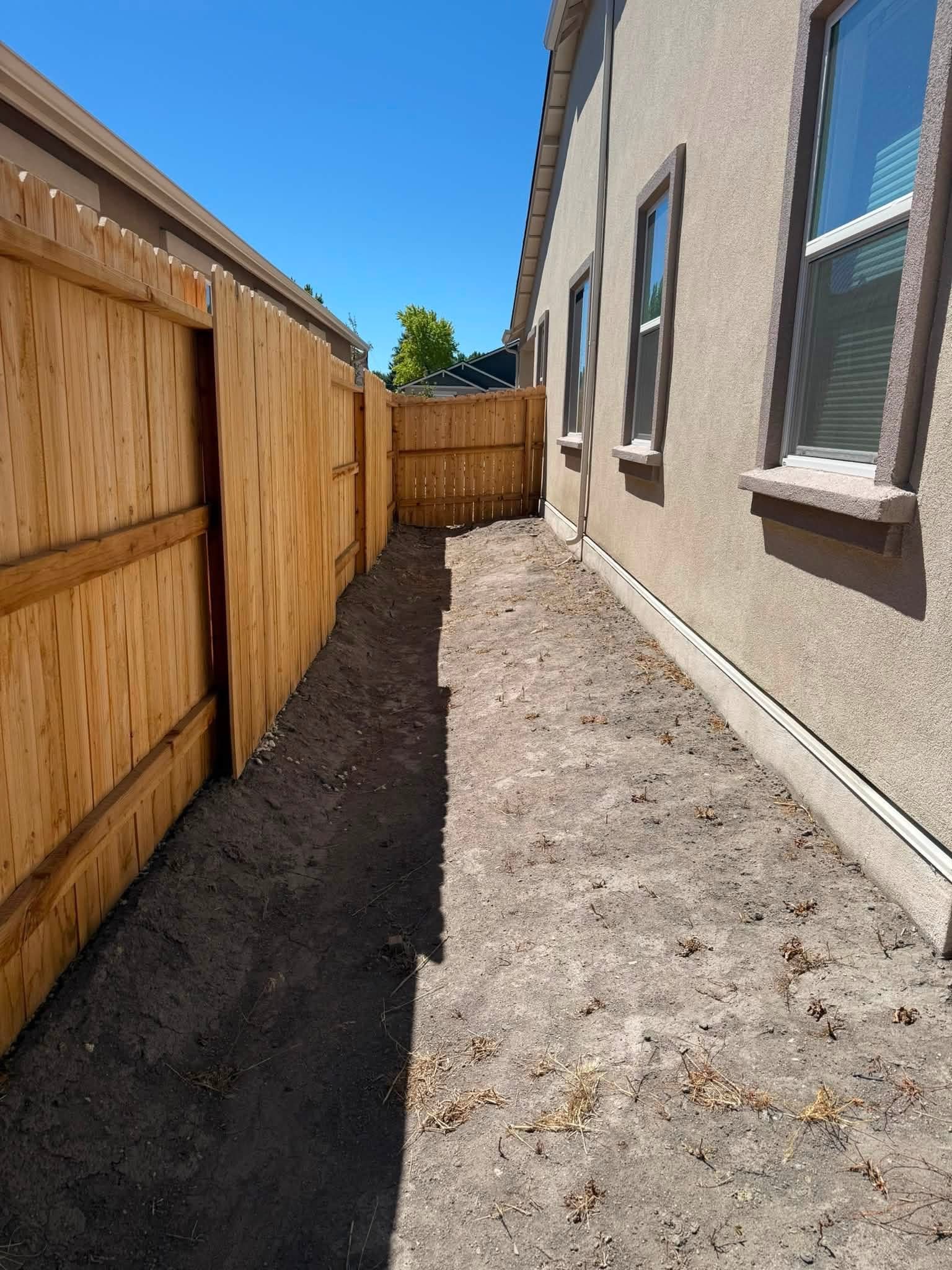 Side yard before landscaping, bare dirt